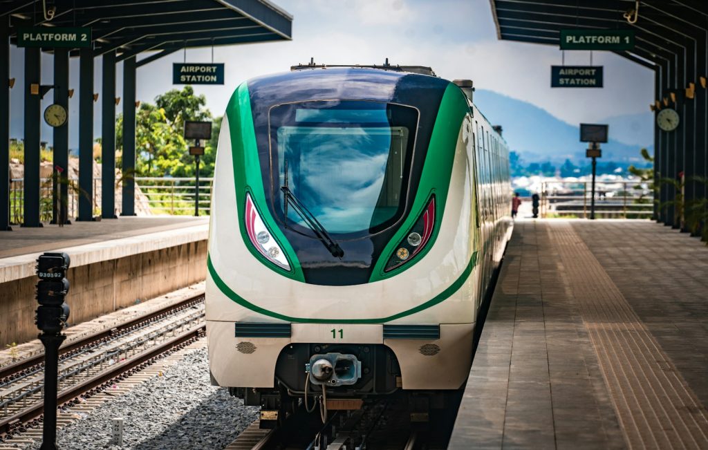 A green and white train pulling into a train station