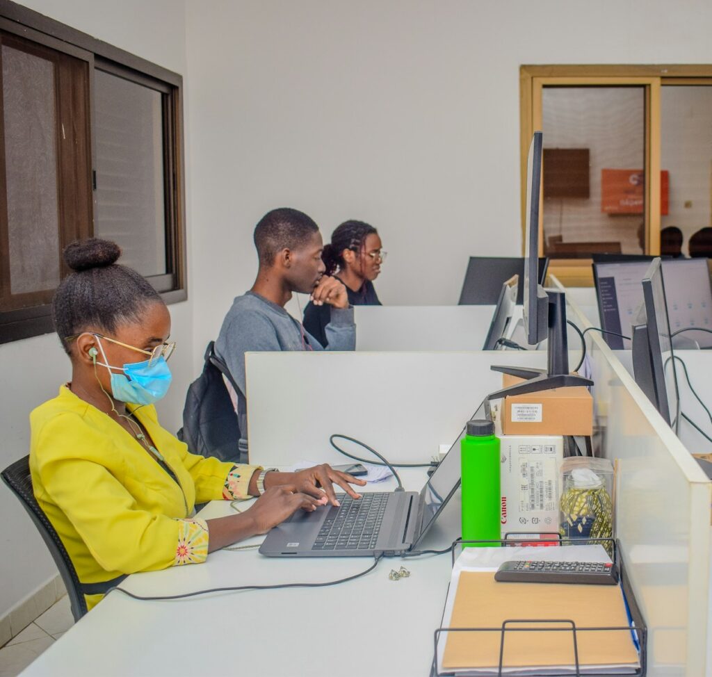 A group of people sitting at a table with laptops