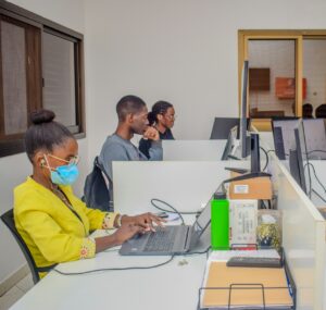 A group of people sitting at a table with laptops