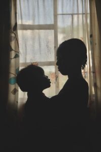 a silhouette of a woman and a dog in front of a window
