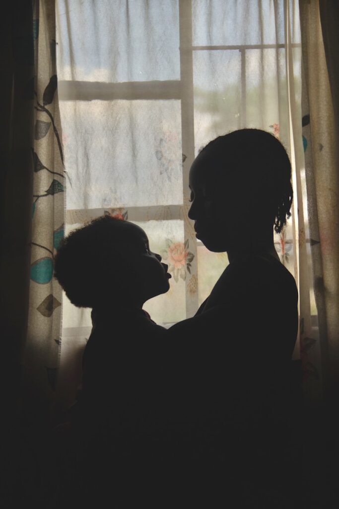 a silhouette of a woman and a dog in front of a window